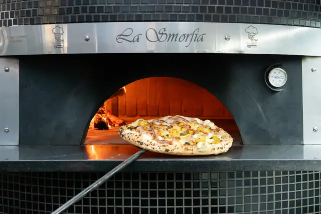 Pizza coming out of the oven