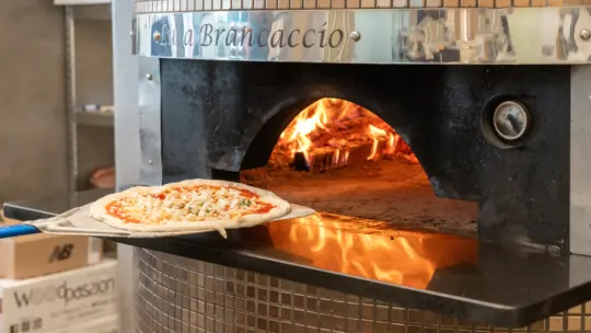 Putting pizza in oven
